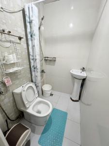 a bathroom with a toilet and a sink at San Marino Residences in Cebu City