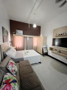 um quarto com duas camas e um sofá e uma televisão em San Marino Residences em Cebu