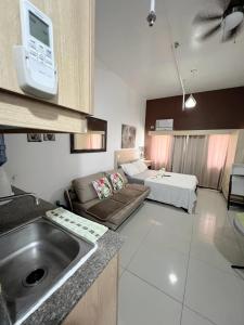 a kitchen with a sink and a living room at San Marino Residences in Cebu City