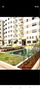 un gran edificio de apartamentos con piscina frente a él en Cosy appartement, en Nouaceur