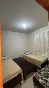 um quarto com duas camas e uma janela em Casa Unamar em Cabo Frio