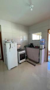 Il comprend une cuisine équipée d'un réfrigérateur blanc et d'une cuisinière. dans l'établissement Casa Unamar, à Cabo Frio