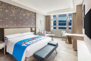 a hotel room with a bed and a television at Shanghai Marriott Hotel Pudong South in Nanhui