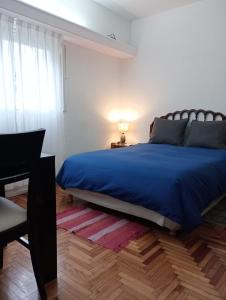 1 dormitorio con cama azul y escritorio en Castex y Salguero en Palermo Chico 10min Aeroparque 100m Mater Dei en Buenos Aires