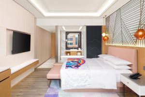 a hotel room with a bed and a television at Shanghai Marriott Hotel Pudong South in Nanhui