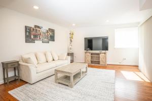 a living room with a white couch and a tv at Comfy and Cozy-Min to National Mall Great Location in Arlington