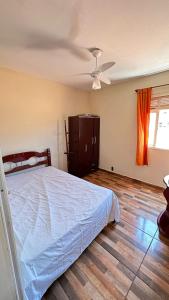 1 dormitorio con 1 cama y ventilador de techo en Casa de Praia, en Arraial do Cabo