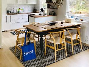 uma cozinha com uma mesa de madeira e cadeiras com um saco azul em Holiday home KYRKESUND VI em Kyrkesund