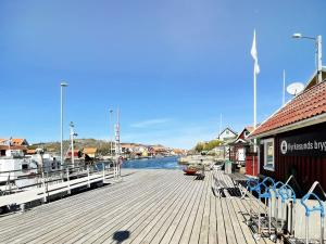uma doca de madeira com cadeiras e uma marina em Holiday home KYRKESUND VI em Kyrkesund