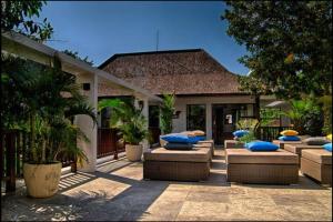 a patio with couches and blue pillows in front of a house at Villa Amira Legian in Legian