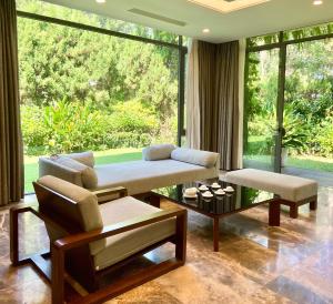 sala de estar con sofá y ventana grande en Suha villa-3PN Flamingo Dai Lai resort, en Phúc Yên