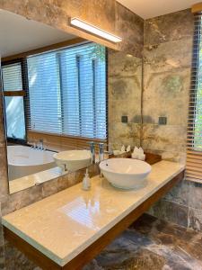 baño con 2 lavabos, bañera y espejo grande en Suha villa-3PN Flamingo Dai Lai resort, en Phúc Yên