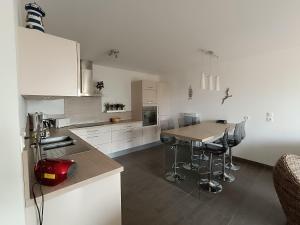 uma cozinha com armários brancos e uma mesa de madeira em Appartement Saint-Brevin-les-Pins, 3 pièces, 4 personnes - FR-1-364-162 em Saint-Brévin-les-Pins