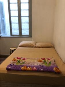 a bed with a blanket with flowers on it at Hostel Bahia in Porto Alegre
