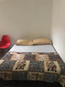 a bedroom with a bed with a blanket on it at Hostel Bahia in Porto Alegre