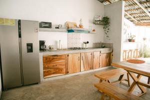 - une cuisine avec des placards en bois, une table et un réfrigérateur dans l'établissement Villa Makai 1 Orange, à El Paredón Buena Vista