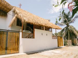 dom z dachem krytym strzechą i bramą w obiekcie Villa Makai 1 Orange w mieście El Paredón Buena Vista