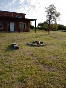 un patio con un edificio y un árbol en el césped en La pacaa` en Bella Vista