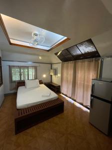 1 dormitorio con 1 cama blanca y nevera en Roy's Rendezvous Boracay en Boracay