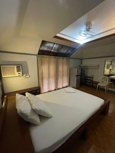 a bedroom with a large white bed in a room at Roy's Rendezvous Boracay in Boracay