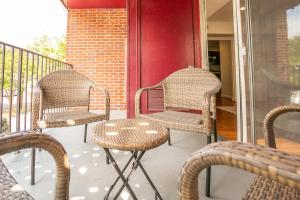 three wicker chairs and a table on a porch at Comfy and Cozy-Min to National Mall Great Location in Arlington