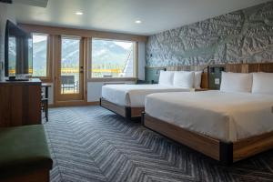 班夫Hotel Canoe and Suites的有两张床和一台电视的酒店房间