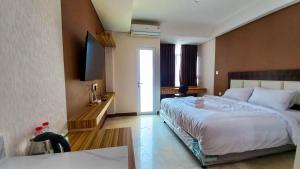 a bedroom with a bed and a flat screen tv at Ayostay at B Residence Serpong in Cilandak