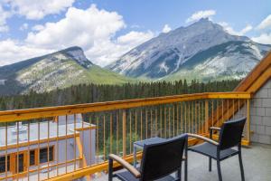 a balcony with two chairs and a view of mountains at Hotel Canoe and Suites in Banff