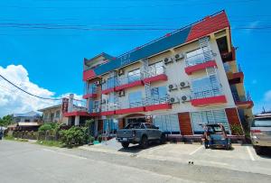 a building with a truck parked in front of it at RedDoorz @ LQJ Hotel Old Buswang Kalibo in Kalibo