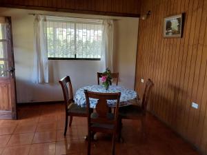 uma sala de jantar com uma mesa e cadeiras e uma janela em Te Ra'a Travel - Cabaña equipada em Hanga Roa