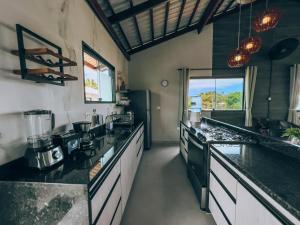 a large kitchen with black counter tops and appliances at Mar e Lar in Maragogi