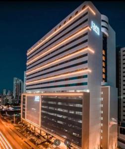 un edificio de hotel iluminado en una ciudad por la noche en Empresarial Jam flat em olinda, en Olinda