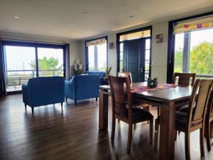 a dining room with a table and chairs and windows at Casa con vista al mar in Pelluhue