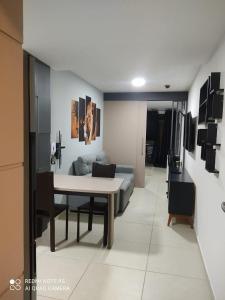 sala de estar con mesa y sofá en Empresarial Jam flat em olinda, en Olinda