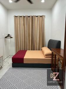 a bed sitting in a room with a curtain at Nz comfort house pandan kuantan in Kuantan