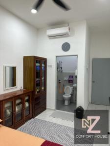 um quarto com casa de banho com WC e espelho em Nz comfort house pandan kuantan em Kuantan