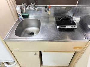 a kitchen counter with a sink and a stove at A&C STAY Shin-Osaka Higashikuchi 83 in Osaka