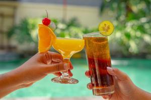 クタにあるBali Summer Hotel by Amertaの二人の手に二杯の飲み物を持つ