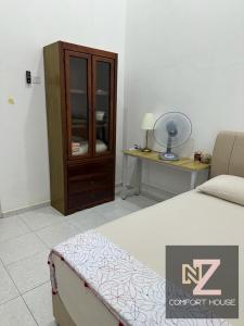 a bedroom with a bed and a dresser and a desk at Nz comfort house pandan kuantan in Kuantan