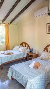 1 dormitorio con 2 camas y ventana en Diuwak, en Dominical