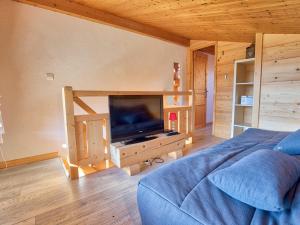 un soggiorno con una tv e un letto blu di Charmant duplex rénové, 34 m², 4 pers, vue Mont Charvin - FR-1-505-25 a Notre-Dame-de-Bellecombe