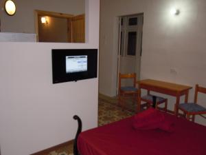 a room with a bed and a table and a television at Number 20 in Birgu
