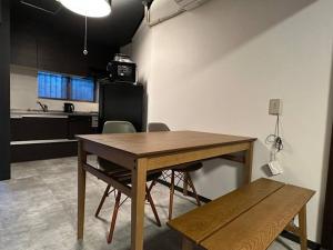 una cucina con tavolo e sedie in una stanza di TasoneUrbanStayOsaka 梅田中津2 ad Osaka