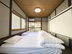 una camera con due letti con cuscini sopra di TasoneUrbanStayOsaka 梅田中津2 ad Osaka