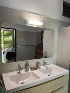 baño con lavabo y espejo grande en The Fare Rohivai BORA BORA, en Bora Bora