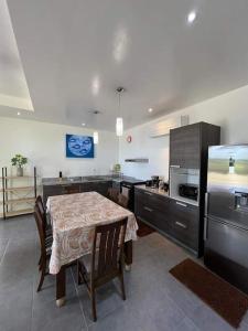 uma cozinha com uma mesa com cadeiras e um frigorífico em The Fare Rohivai BORA BORA em Bora Bora