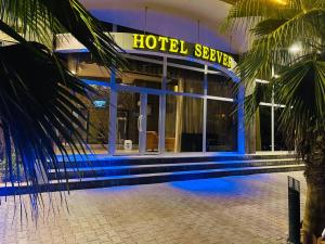 een hotelbuitenkant met een hoteliger bordje 's nachts bij Hotel Seever in Erbil
