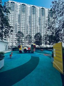 a park in front of a large apartment building at Family friendly apartment @Southville City in Kampong Tangkas