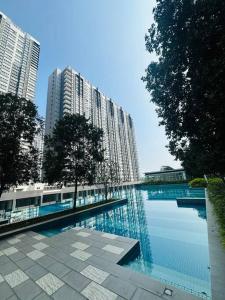 a large swimming pool in a city with tall buildings at Family friendly apartment @Southville City in Kampong Tangkas