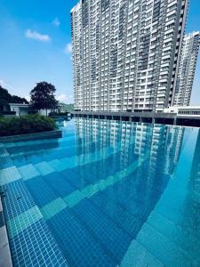 a large swimming pool in front of a tall building at Family friendly apartment @Southville City in Kampong Tangkas